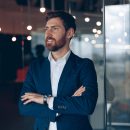 Handsome confident businessman thinking about a job in a modern office. Business concept